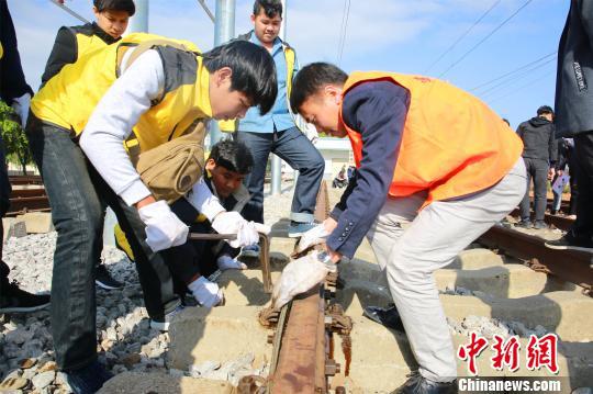 留学生在上高铁轨道基础课，中国教师（右一）指导留学生进行实操。　朱柳融 摄