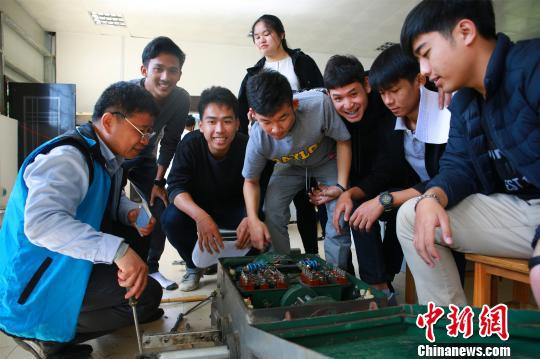 留学生在上高铁信号控制课，中国教师（左一）指导学生进行实操。　朱柳融 摄