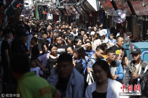 资料图：去年中秋，在山东济南芙蓉街老街巷景区，来自全国的游客聚集在老街里，形成人海景观。 图片来源：视觉中国